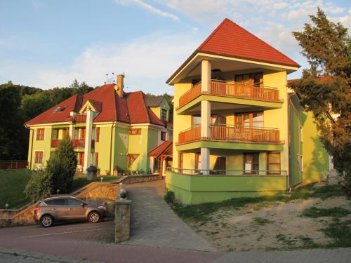 een geel huis met een auto ervoor geparkeerd bij Penzion Stella in Luhačovice