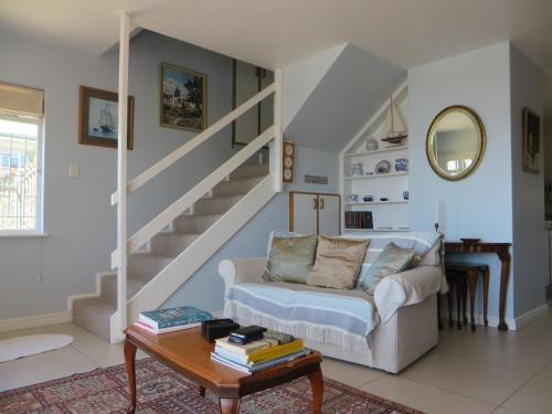 ein Wohnzimmer mit einem Sofa und einer Treppe in der Unterkunft No. 1 Living Waters in Simonʼs Town