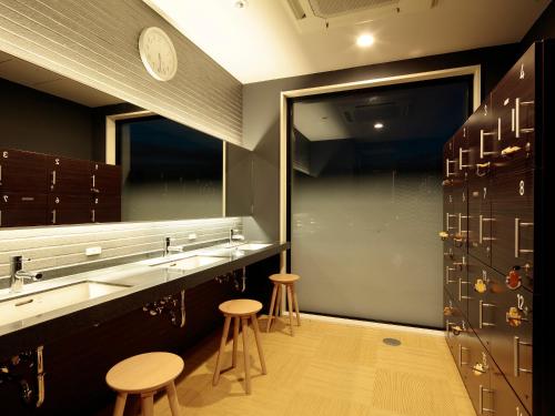 a dressing room with stools and a counter and some cabinets at Candeo Hotels Handa in Handa