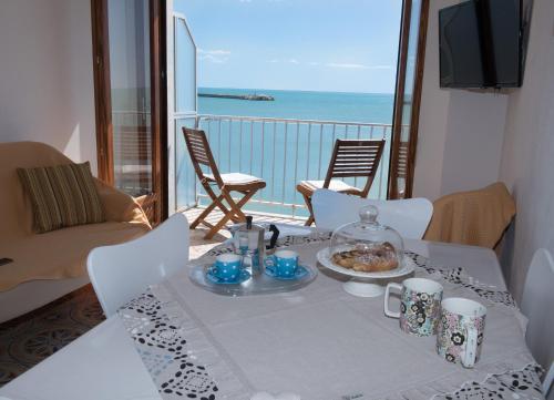 a table with a plate of food on a balcony at Appartamento Mare Blu in Sciacca