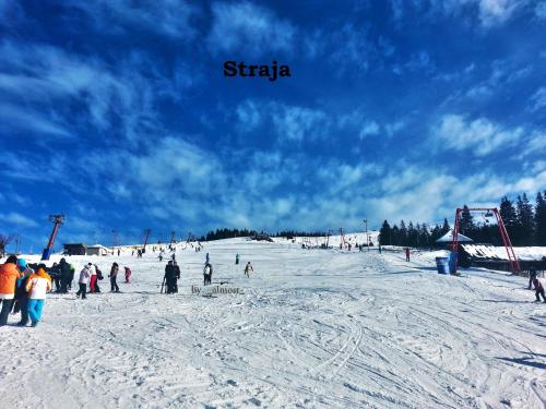 a group of people on a snow covered ski slope at Pensiunea Avy in Haţeg