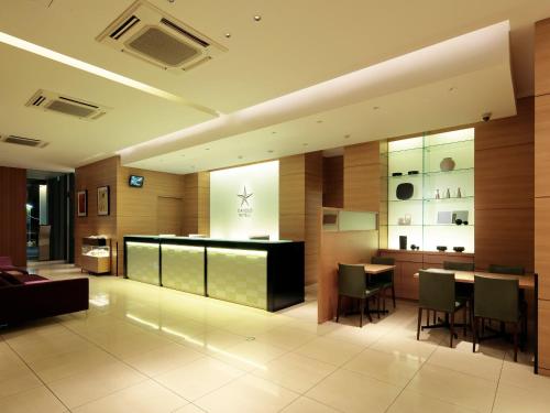 a lobby with a bar and a table and chairs at Candeo Hotels Handa in Handa
