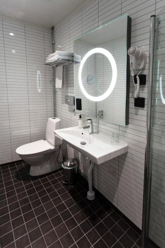 a bathroom with a sink and a toilet and a mirror at Best Western Hotel Baltic in Sundsvall