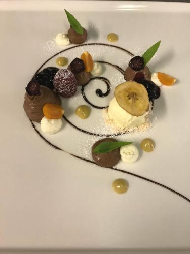 a dessert with chocolate and fruit on a white plate at Hotel Vista Allegra in Ischgl