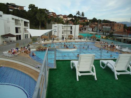 una gran piscina con sillas y gente en ella en Ciudadela Santafe, en Santa Fe de Antioquia