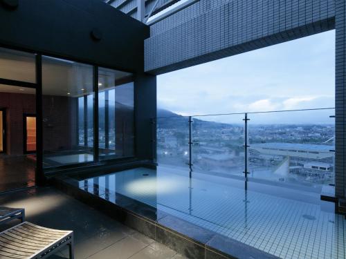 an indoor swimming pool in a building with a view at Candeo Hotels Chino in Chino
