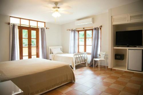 ein Schlafzimmer mit einem Bett und einem Flachbildfernseher in der Unterkunft Contadora Island Inn in Isla Contadora
