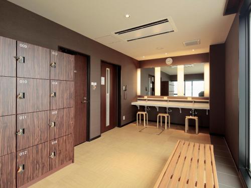 a room with lockers and a counter with a bar at Candeo Hotels Ozu Kumamoto Airport in Ozu