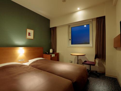 une chambre d'hôtel avec un lit et une fenêtre dans l'établissement Candeo Hotels Kameyama, à Kameyama