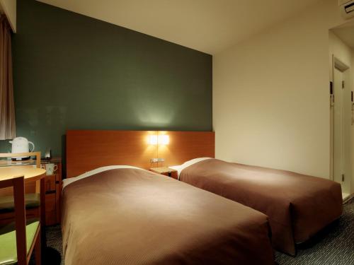 Giường trong phòng chung tại Candeo Hotels Kameyama