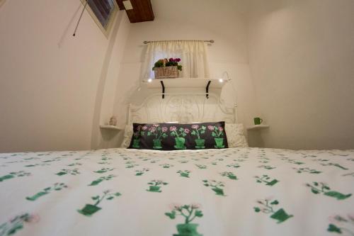 a bedroom with a white bed with flowers on it at A Casa Di Agata in Pellezzano