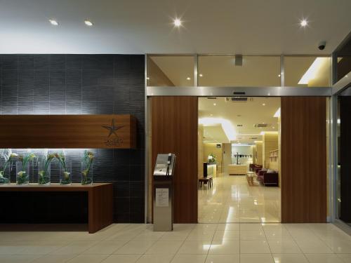 a lobby with a counter with vases on the wall at Candeo Hotels Shizuoka Shimada in Shimada