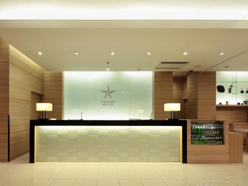 a lobby with a counter with two lamps on it at Candeo Hotels Shizuoka Shimada in Shimada