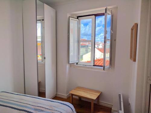 リスボンにあるCentral Lisbon Flat with a Viewのベッドルーム1室(ベッド1台、窓2つ、テーブル付)