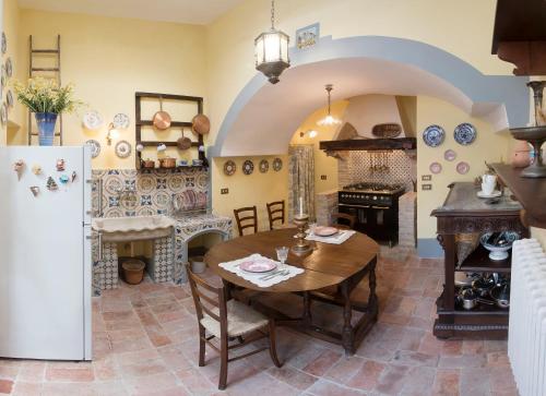 a kitchen and dining room with a table and a refrigerator at Il Teatro Di Nerone in Naples