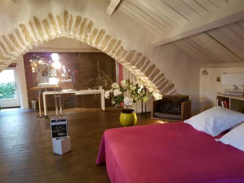 - une chambre avec un lit rouge et une voûte dans l'établissement La Terrasse de Peyre, à Comprégnac