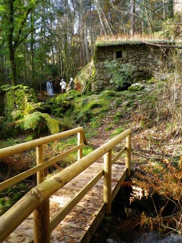 a wooden bridge over a path in the woods at Cruceiro do Monte in Tui