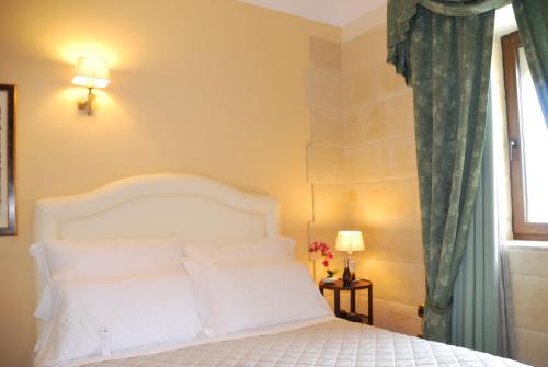 a bedroom with a white bed and a window at Domus Mariae Benessere in Siracusa