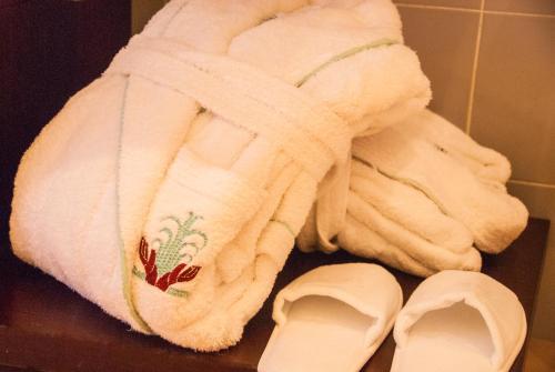 a towel and pair of shoes next to a towel at Domus Mariae Benessere in Siracusa