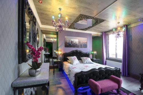 a bedroom with a bed and a chair and a chandelier at Chambres d'hôtes & Gîtes La Paysanne in Fresnes-en-Woëvre