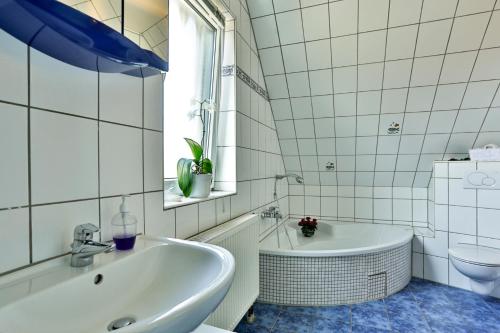 uma casa de banho branca com uma banheira e um lavatório em Ferienhaus Kottmann em Bremerhaven