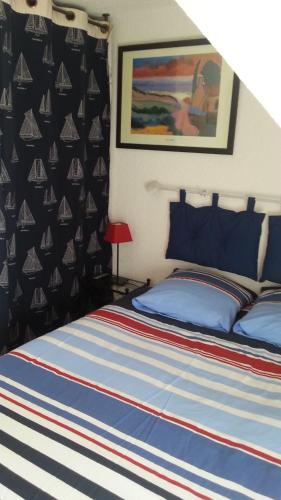 ラ・トリニテ・シュル・メールにあるLa Maison Du Pecheurのベッドルーム1室(青と赤のストライプ毛布付きのベッド1台付)