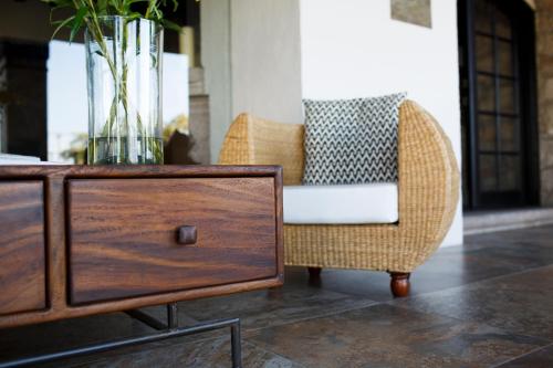 a wicker chair and a table with a vase on it at Maja Hotel Boutique in Morelia