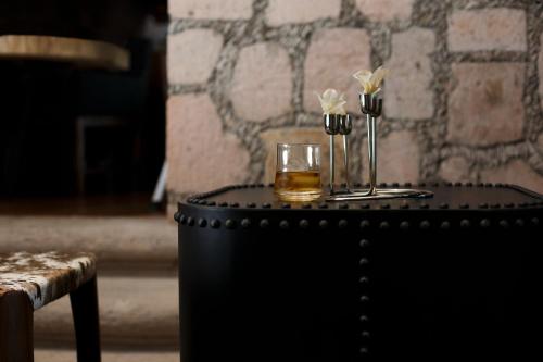 a table with a glass of whiskey and flowers on it at Maja Hotel Boutique in Morelia