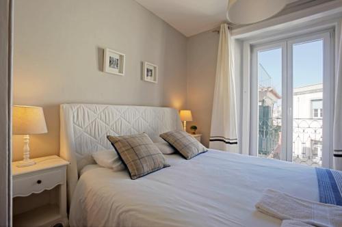 a bedroom with a white bed with a window at Duque-Chiado Downtown in Lisbon