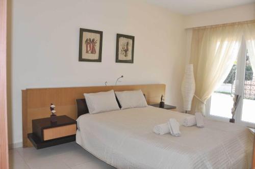 1 dormitorio con 1 cama con 2 toallas en Beautiful house with garden in Rhodes en Ialyssos