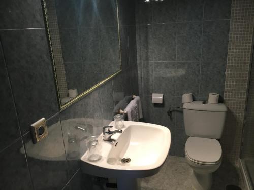 a bathroom with a sink and a toilet at Hostal El Pinar in Ávila