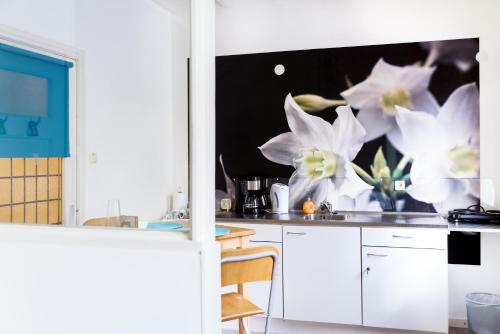 a kitchen with white flowers on the wall at Studio RoSa in Nijmegen