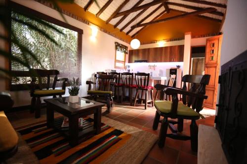 a room with chairs and a table and a bar at La Estancia de la Pradera Cabana Fiba in Nobsa