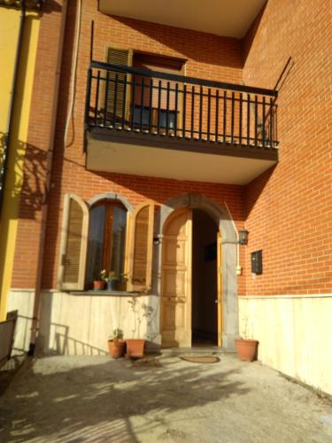 a brick building with a balcony and a door at B&B Tufaro Alberico in Terranova di Pollino