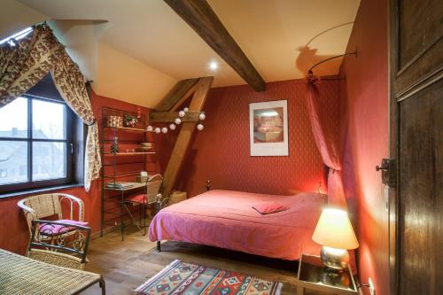 a bedroom with red walls and a bed and a window at La Ferme Des Eglantines in Nivelles