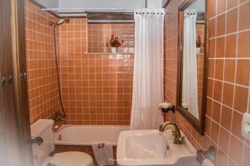 a bathroom with a tub and a sink and a toilet at Apartamentos Rurales El Foro in Andés