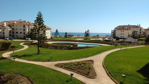 a walkway around a park with a swimming pool at A Pasos de la Playa in Papudo