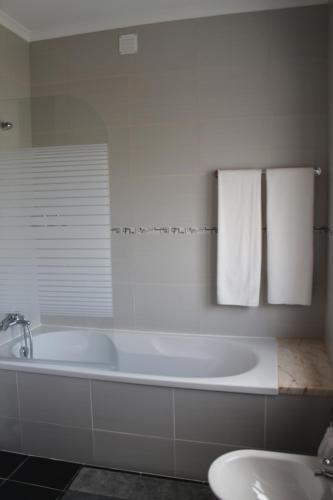 a white bathroom with a tub and a sink at Refúgio da Sancheira Grande in Óbidos