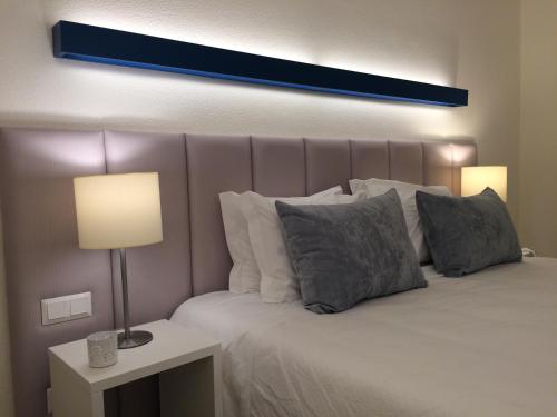- une chambre dotée d'un grand lit avec une lumière bleue au-dessus dans l'établissement Hotel D'Alcoutim, à Alcoutim