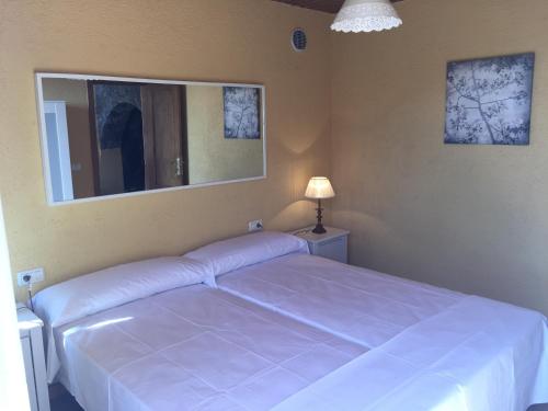 1 dormitorio con 1 cama blanca grande y espejo en Casa Reyes, en San Sebastián de la Gomera