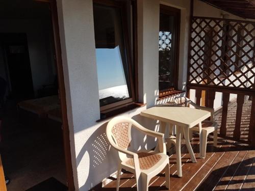 une véranda avec une table, des chaises et une fenêtre dans l'établissement Studios Sea View, à Nessebar