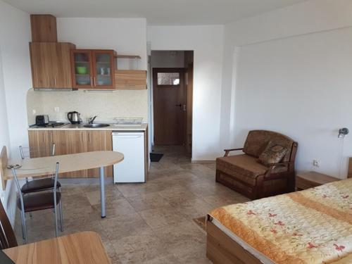 Studios Sea View في نيسيبار: مطبخ وغرفة معيشة بها سرير وطاولة
