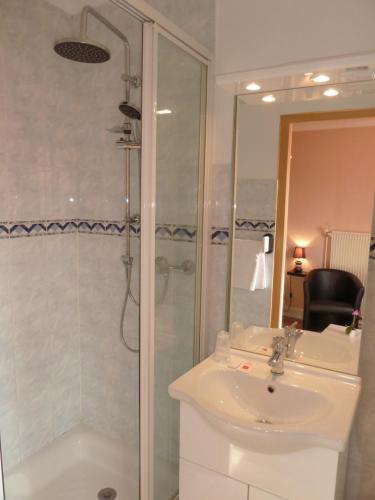 a bathroom with a sink and a shower and a toilet at Hotel Le Beauregard in Divonne-les-Bains