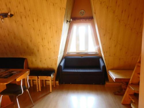 a small room with a black couch and a window at Willa pod piórem in Szczyrk