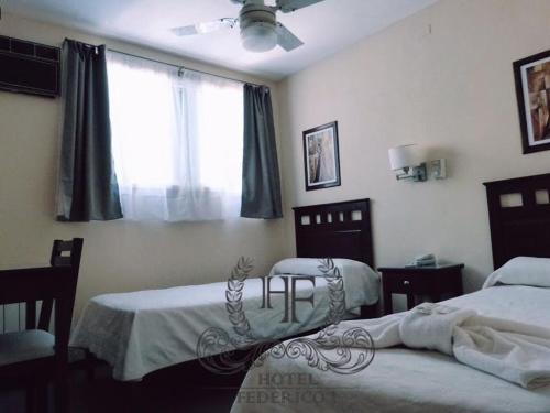 a bedroom with two beds and a window at Hotel Federico I in Concordia