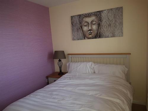 a bedroom with a bed with a picture of a head at Jane's Villa Free Parking in Inverness