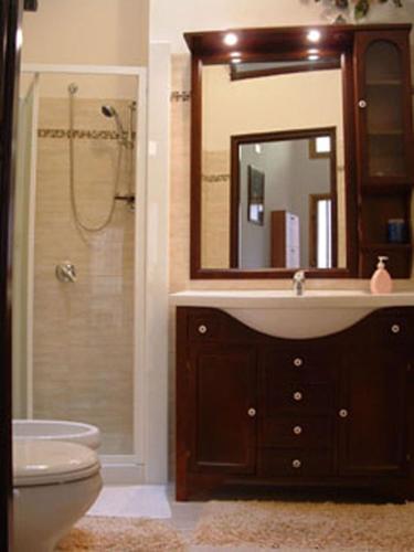 a bathroom with a sink and a toilet and a mirror at La Corte di Zaccaria in Mazara del Vallo