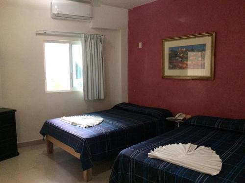 a hotel room with two beds and a window at Casa del Parque Vallarta in Puerto Vallarta