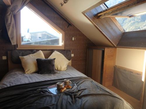 un lit dans une chambre avec une grande fenêtre dans l'établissement Chamonix IRIS, à Chamonix-Mont-Blanc