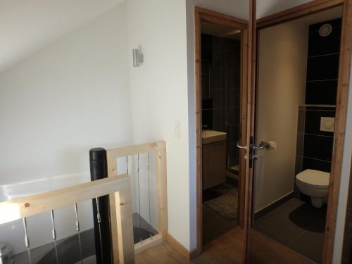 - une petite salle de bains avec des toilettes et une porte dans l'établissement Chamonix IRIS, à Chamonix-Mont-Blanc